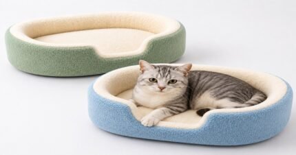 Two oval foam cat beds in light green and blue with soft cream fleece lining and a gray tabby cat resting inside.